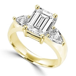 Simple and elegant wide band showing off 2 carat Radient Emerald Diamond Essence with 0.5 carat Pear cut Diamond Essence on each side set in 14K Solid Gold.
