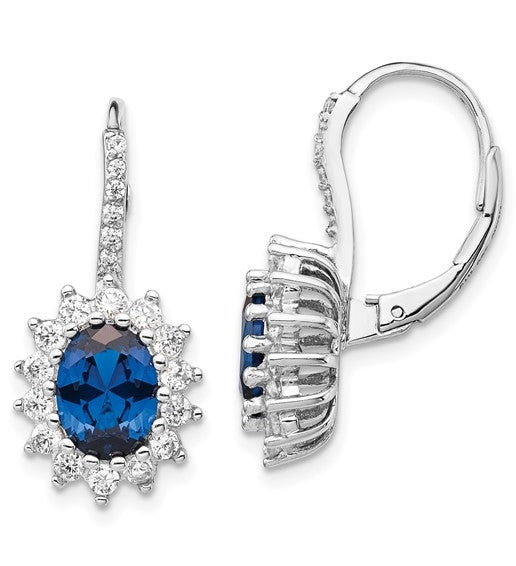 An alluring pair of prong set earrings for women with simulated oval cut sapphire in center surrounded by round brilliant melee Diamonds in floral pattern by Diamond Essence set in platinum plated sterling silver. 5.0 Cts.t.w.