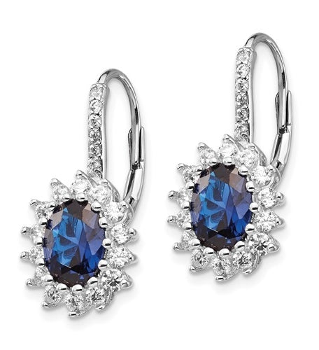 An alluring pair of prong set earrings for women with simulated oval cut sapphire in center surrounded by round brilliant melee Diamonds in floral pattern by Diamond Essence set in platinum plated sterling silver. 5.0 Cts.t.w.