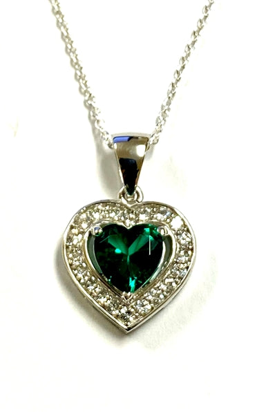 Heart shape Emerald Essence stone in prong setting, is surrounded by round brilliant Diamond Essence stones, making another heart. 2.5 cts.t.w. in Platinum Plated Sterling Silver.
