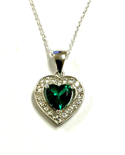 Heart shape Emerald Essence stone in prong setting, is surrounded by round brilliant Diamond Essence stones, making another heart. 2.5 cts.t.w. in Platinum Plated Sterling Silver.