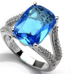 Diamond Essence Ring with 6 Ct. Blue Cushion Cut Stone and Melee on band, 6.15 Cts.T.W. in Platinum Plated Sterling Silver.