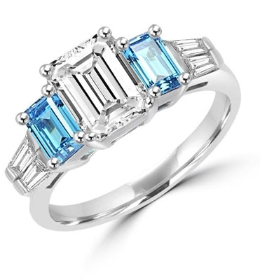 Classic Wide Ring with a 2 Ct. Emerald Cut Brilliant Masterpiece in the center, saluted on each side by a 0.5 ct. Emerald Cut Aquamarine Stone and clear white Baguette Masterpieces further down. 3.5 Cts. T.W, in Platinum Plated Sterling Silver.