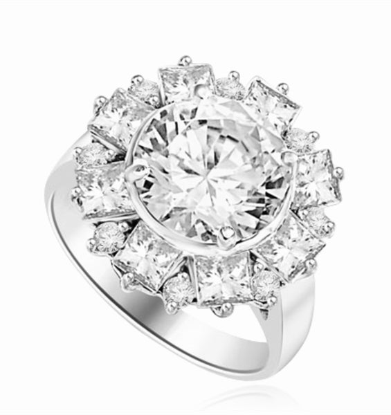 Diamond Essence Designer Ring With Round Brilliant Diamond Essence in center surrounded by alternately set Princess and melee. 7.25 Cts. T.W. set in Platinum Plated Sterling Silver.