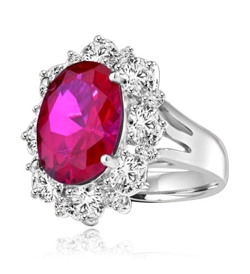 Gorgeous Ring with 8.25 Cts. Oval Cut Ruby Essence in center, surrounded by Oval cut Diamond Essence and Round Brilliant Melee. 10.25 Cts T.W. set in Platinum Plated Sterling Silver.