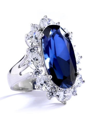 Sapphire Ring - 13 Cts. Long Oval cut Sapphire Essence set in center surrounded by Oval Diamond Essence and Melee. 16.0 Cts. T.W. set in Platinum Plated Sterling Silver.