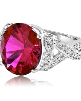 Ruby Ring- 6.0 Cts Oval Cut Ruby Essence in center accompanied by Melee on the band making criss cross design. 6.50 Cts. T.W. set in Platinum Plated Sterling Silver.