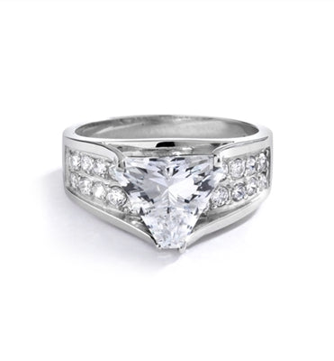 Magnificent Ring with 4Ct. Trilliant Cut Center adorning the mount on a glimmering band with melee of Round brilliant accents. 5.5 Cts. T.W. in 14k Solid White Gold.