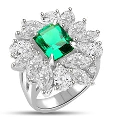 Diamond Essence classic cocktail ring. 2.5 Ct. Radient Emerald cut Emerald Essence surrounded by marquise cut and pear cut Diamond Essence in floral setting. 11.0 cts.t.w set in 14K Solid White Gold.