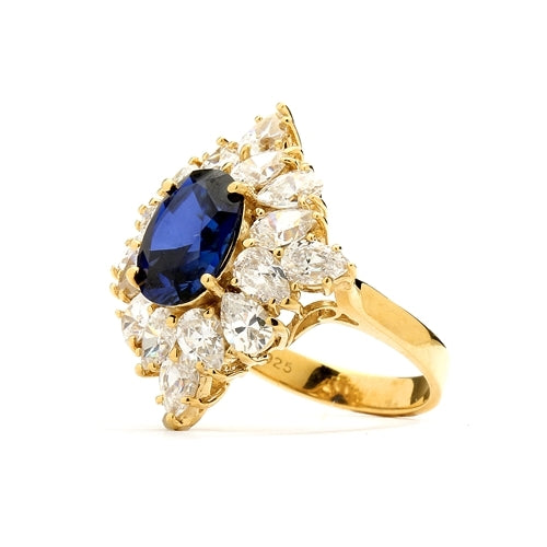 Designer ring with 3.5 Ct. oval Sapphire Essence set in four prongs, and surrounded by pear cut diamond essence stones in floral pattern. 8.5 Cts. T.W. et in 14K Solid Yellow Gold.