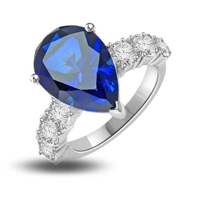 Diamond Essence Designer Ring with 5.50 cts. Pear Cut  Sapphire Essence in center and three round stones on each side of center. 7.0 Cts. T. W. In Platinum Plated Sterling Silver.