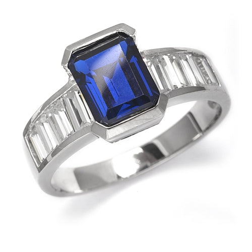 Escape with this Wide Band Ring with Channel Set Emerald cut Sapphire Essence, 2.5 cts., separated by straight Diamond Bright Baguettes set vertically for a totally magnificent effect. 3.5 cts. T.W. set in Platinum Plated Sterling Silver.