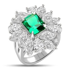 Diamond Essence classic cocktail ring. 2.5 Ct. Radient Emerald cut Emerald Essence surrounded by marquise cut and pear cut Diamond Essence in floral setting. 11.0 cts.T.W. set in Platinum Plated Sterling Silver.
