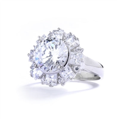Diamond Essence Designer Ring With Round Brilliant Diamond Essence in center surrounded by alternately set Princess and melee. 7.25 Cts. T.W. set in Platinum Plated Sterling Silver.